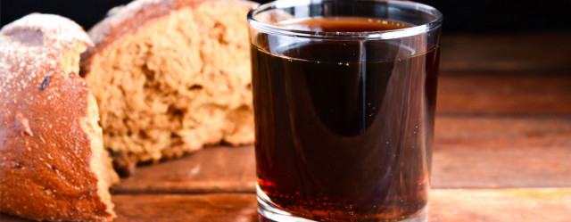 loaf of bread next to a glass of dark beer