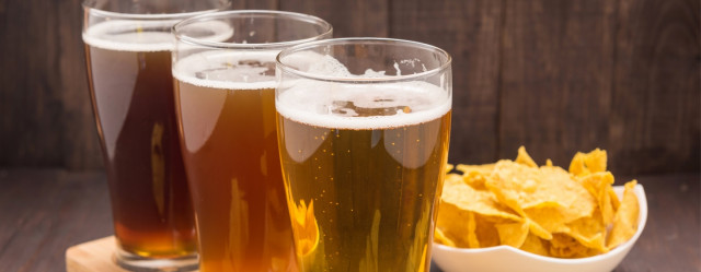 Three Mexican-style lagers with chips in background Three Mexican-style lagers with chips in background