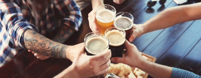 A group of people performing a toast with beer