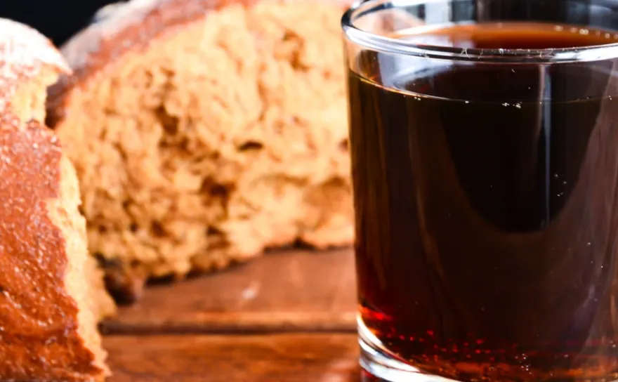 loaf of bread next to a glass of dark beer
