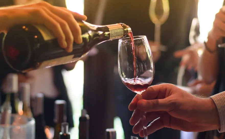 A woman serving a man a glass of whine