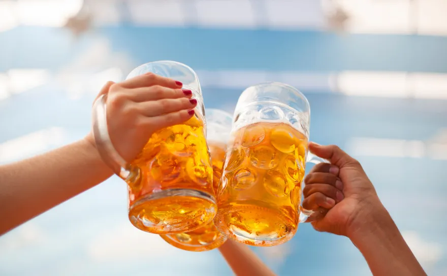 Beer glasses being clinked.