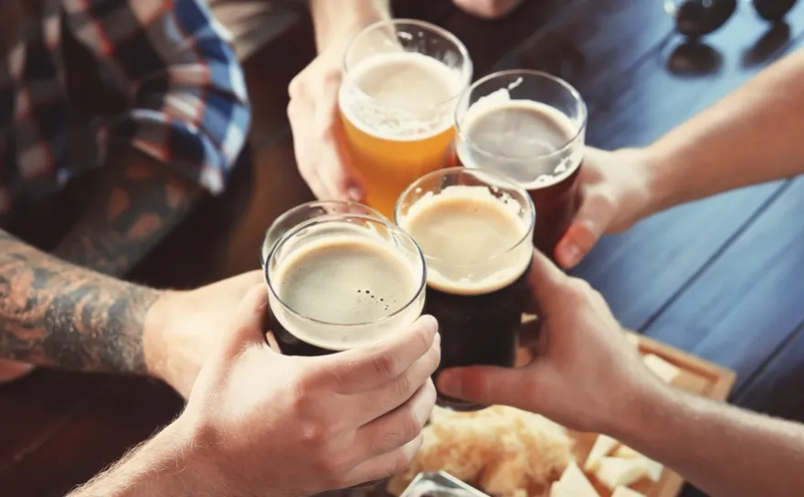 A group of people performing a toast with beer